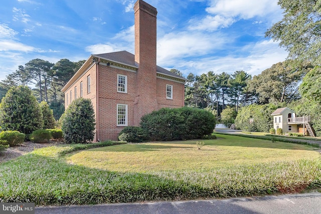 view of side of home with a yard