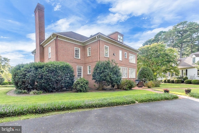 view of front of property featuring a front yard and cooling unit