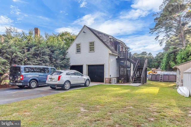 view of side of home with a lawn, a garage, and central air condition unit