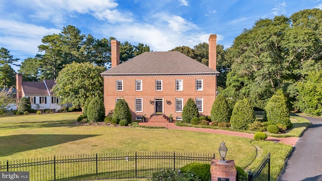 colonial-style house featuring a front lawn