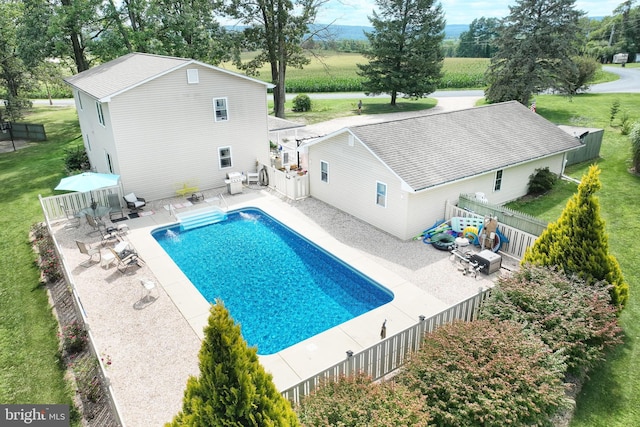 view of pool with a lawn and a patio