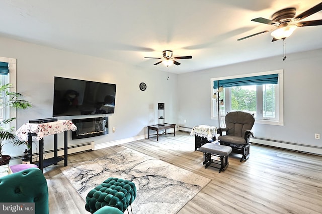 living room with ceiling fan, light wood-type flooring, and baseboard heating