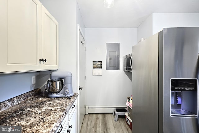 kitchen with electric panel, a baseboard heating unit, stainless steel refrigerator with ice dispenser, light wood-type flooring, and dark stone counters