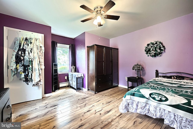 bedroom featuring ceiling fan, light hardwood / wood-style flooring, and baseboard heating