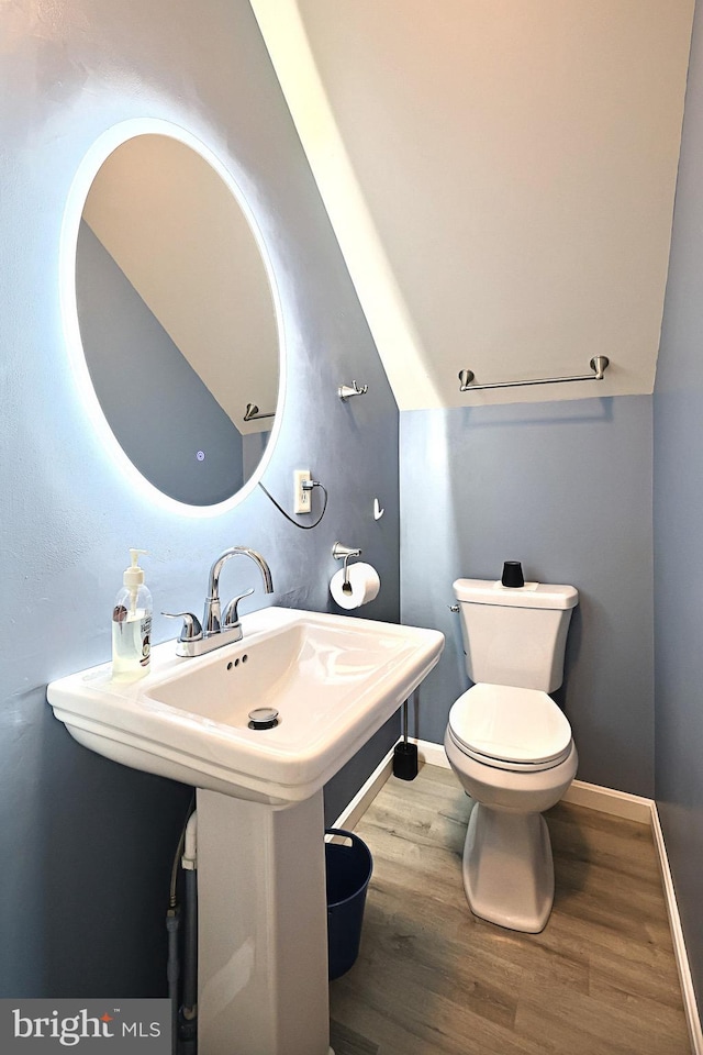 bathroom featuring vaulted ceiling, toilet, hardwood / wood-style flooring, and sink