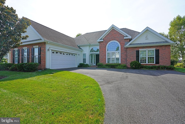 view of front of house featuring an attached garage, brick siding, driveway, roof with shingles, and a front lawn