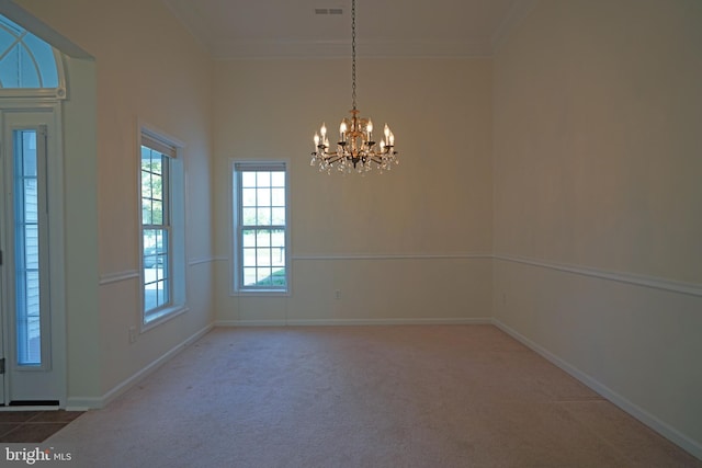 spare room with baseboards, visible vents, ornamental molding, an inviting chandelier, and carpet flooring