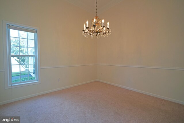 empty room with carpet flooring, a wealth of natural light, an inviting chandelier, and crown molding