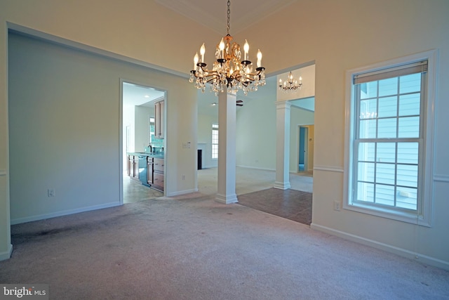 unfurnished dining area with plenty of natural light, carpet flooring, decorative columns, and crown molding