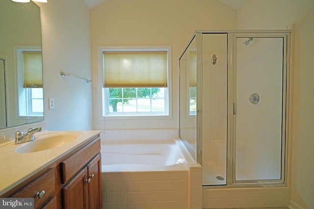 bathroom featuring a wealth of natural light, vanity, vaulted ceiling, and shower with separate bathtub