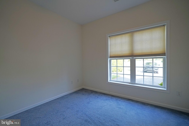 unfurnished room with carpet and baseboards