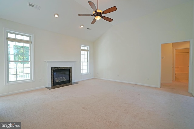 unfurnished living room with ceiling fan, a fireplace, and light carpet