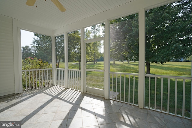 unfurnished sunroom with ceiling fan