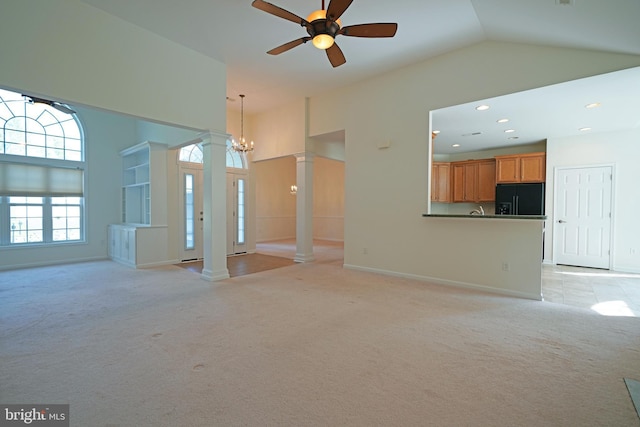 unfurnished living room with high vaulted ceiling, light colored carpet, and ornate columns