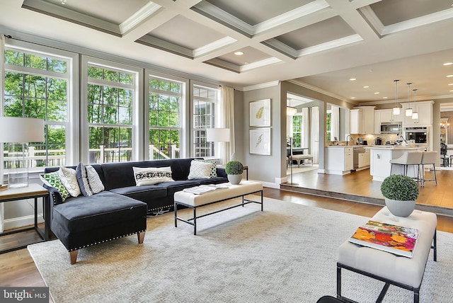 living area featuring coffered ceiling, beamed ceiling, crown molding, light wood-type flooring, and recessed lighting