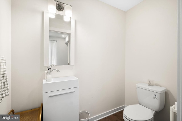 bathroom with wood-type flooring, toilet, and vanity