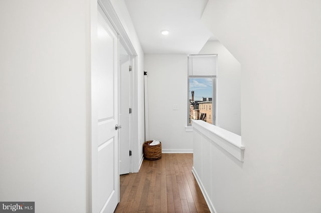 corridor with vaulted ceiling and hardwood / wood-style flooring