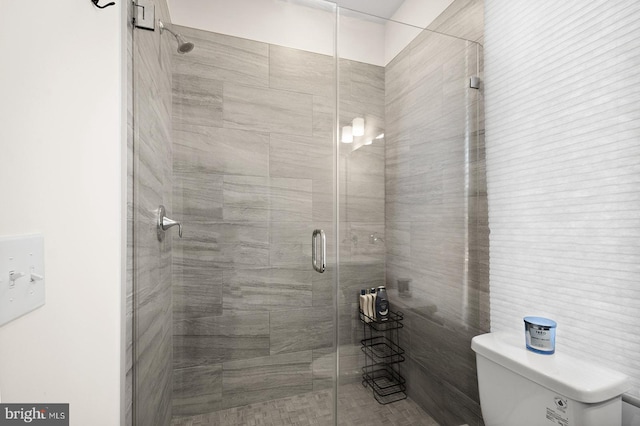 bathroom with tile walls, an enclosed shower, and toilet