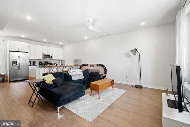 living room featuring ceiling fan and light wood-type flooring