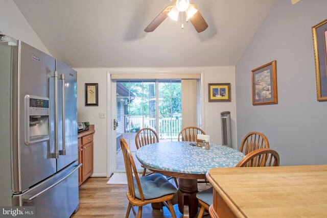 dining room featuring ceiling fan, light hardwood / wood-style floors, and vaulted ceiling