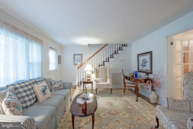 living room featuring visible vents and stairs