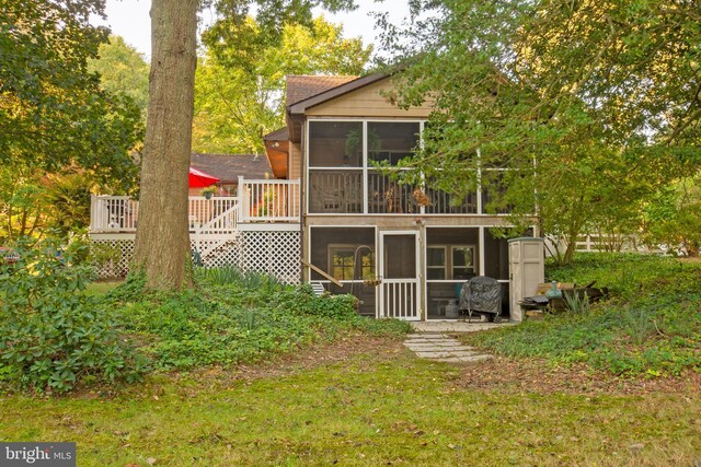 rear view of property with a deck and a sunroom