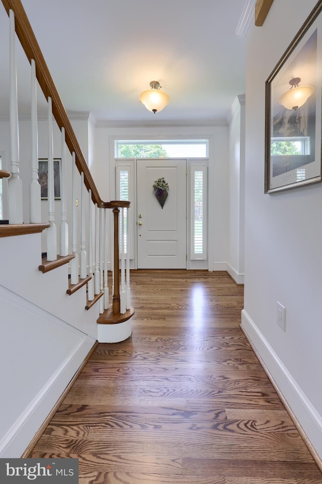 foyer entrance with hardwood / wood-style floors and crown molding