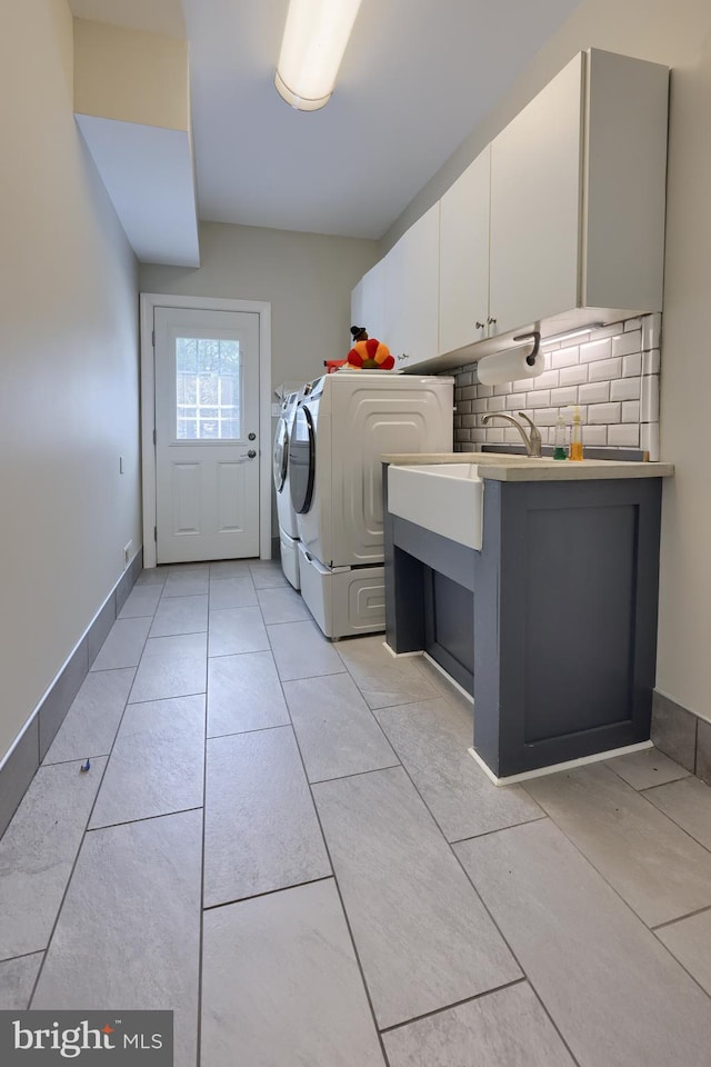 laundry room featuring cabinets, light tile patterned floors, and washer and clothes dryer