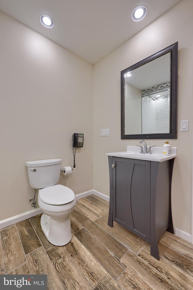 bathroom with vanity, toilet, and hardwood / wood-style flooring