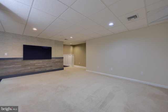 interior space with a paneled ceiling and carpet flooring