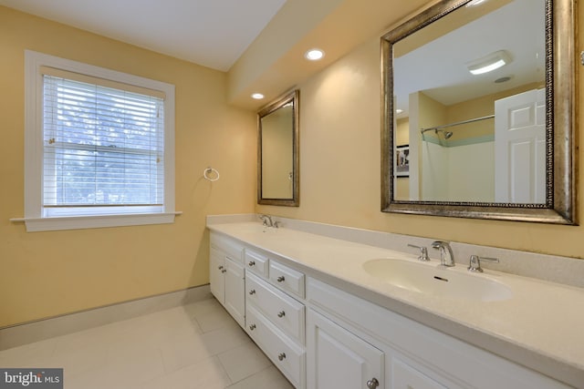 bathroom featuring tile patterned flooring, vanity, and a shower