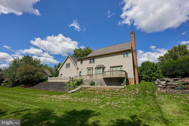 back of property featuring a deck and a lawn