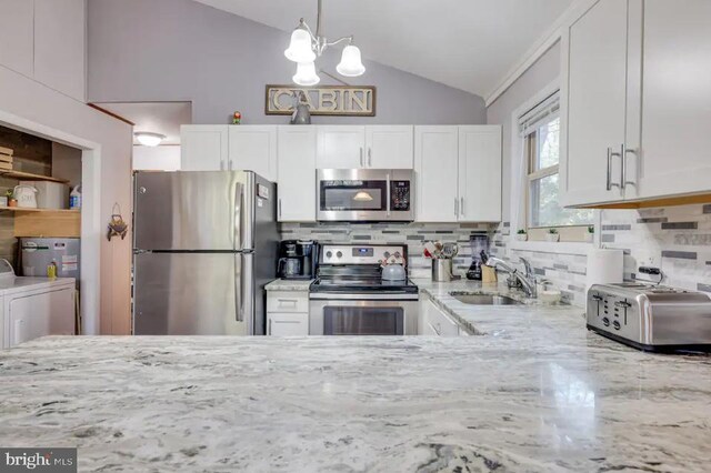 kitchen with appliances with stainless steel finishes, sink, decorative backsplash, and white cabinets