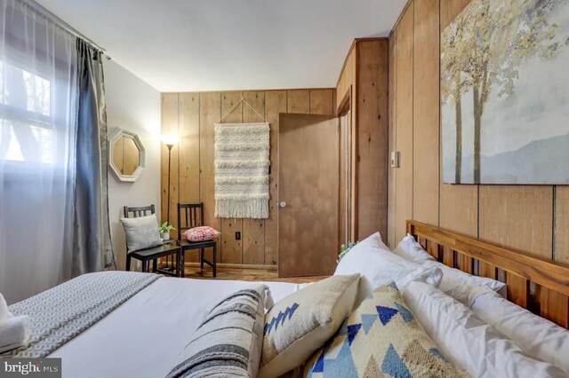 bedroom featuring wooden walls