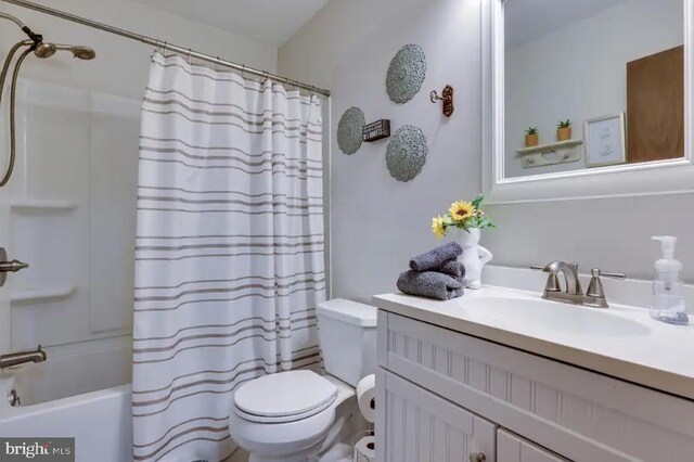 full bathroom featuring toilet, shower / tub combo with curtain, and vanity