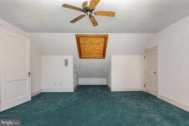 additional living space featuring a textured ceiling, carpet floors, visible vents, baseboards, and vaulted ceiling