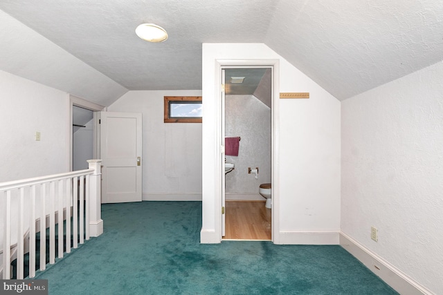 bonus room featuring carpet floors, lofted ceiling, a textured ceiling, and baseboards