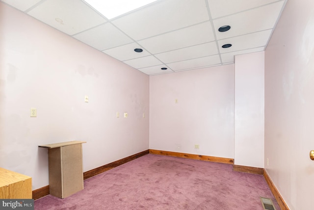 spare room featuring a drop ceiling, carpet, visible vents, and baseboards