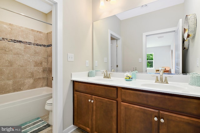 full bathroom with tiled shower / bath combo, vanity, and toilet