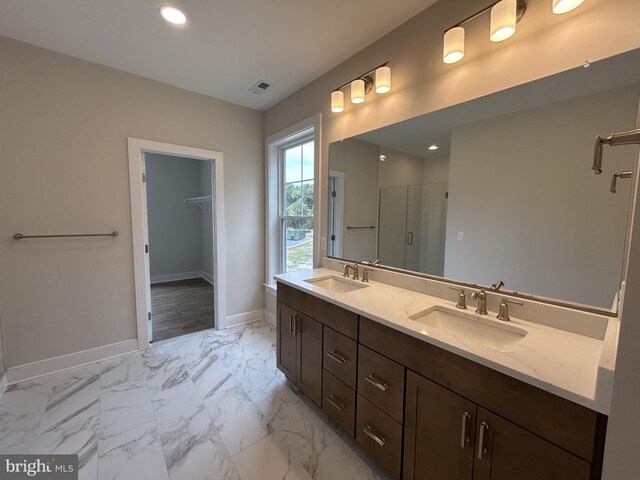 bathroom featuring vanity and a shower with door