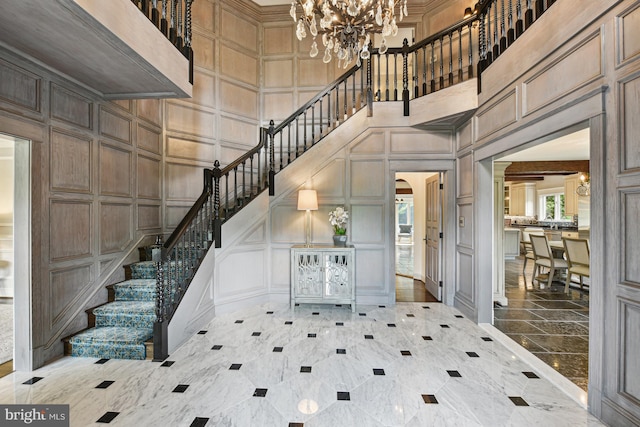 tiled foyer entrance featuring a towering ceiling and an inviting chandelier