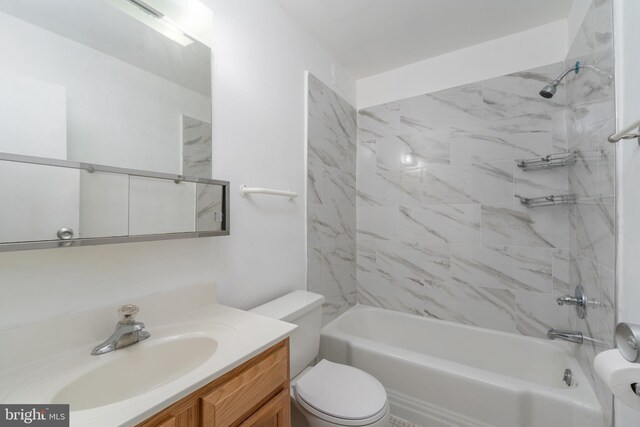 full bathroom featuring tiled shower / bath, vanity, and toilet