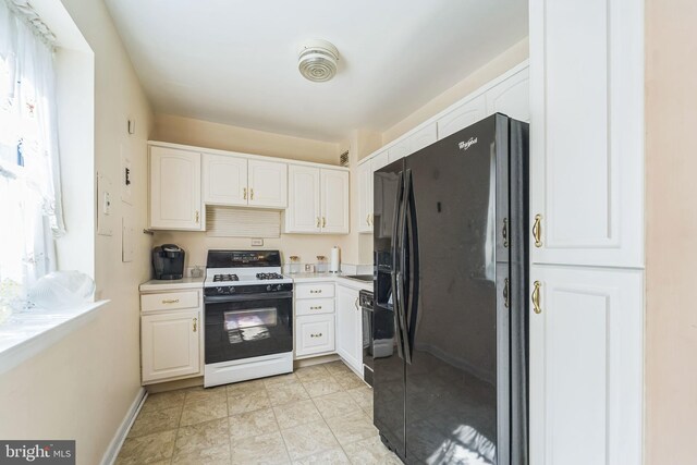 130 Slade Ave Unit 213, Pikesville, MD 21208 - kitchen featuring black fridge, white cabinetry, baseboards, light countertops, and gas stove
