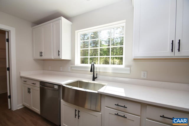 kitchen with light stone counters, white cabinetry, a sink, and stainless steel dishwasher