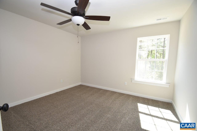 spare room featuring ceiling fan, carpet, visible vents, and baseboards