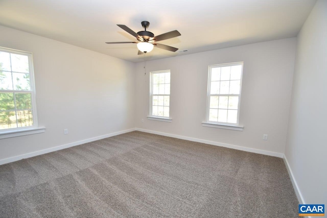 carpeted spare room with baseboards and a ceiling fan