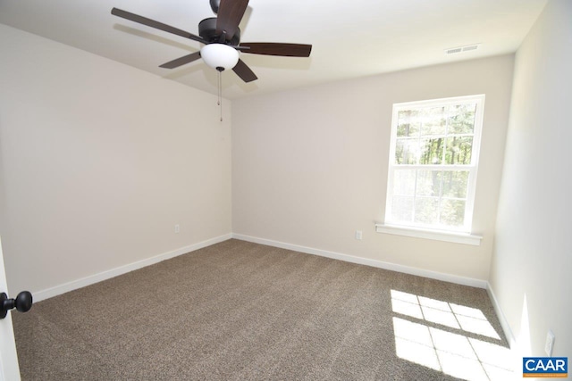 empty room featuring carpet flooring, visible vents, and baseboards