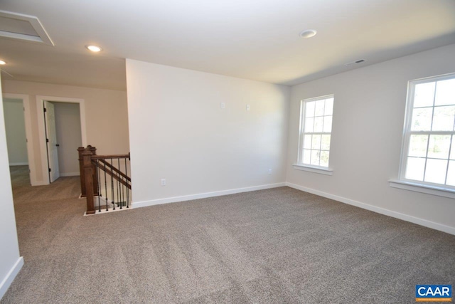 spare room with recessed lighting, carpet, visible vents, and baseboards