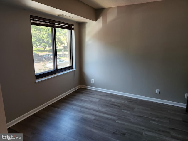 unfurnished room with dark wood-type flooring