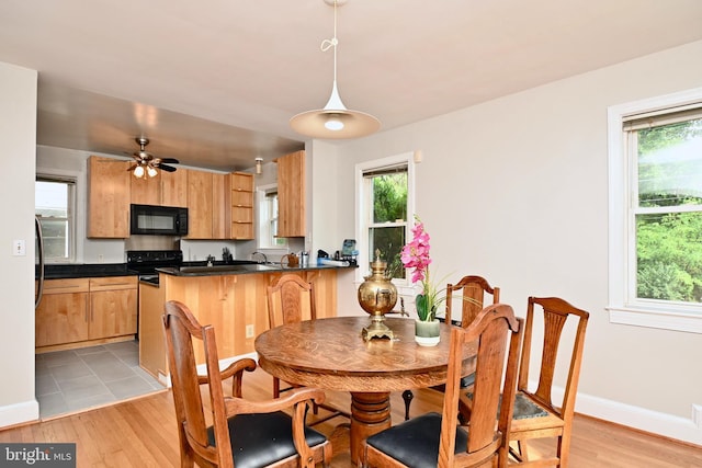 tiled dining area with ceiling fan